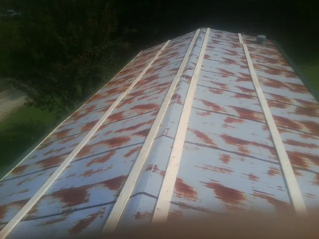 Rusted metal roof panels with new wood purlins before replacement — Storm Damage Roof Repair in Aston by Roofing Brothers