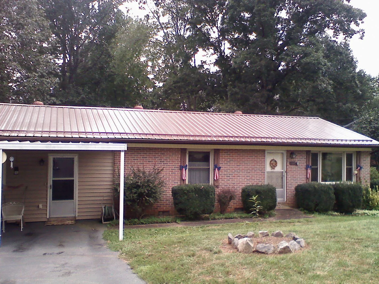 Bronze metal roof and carport on a brick ranch home — Roof Repair work by our crew in Aston
